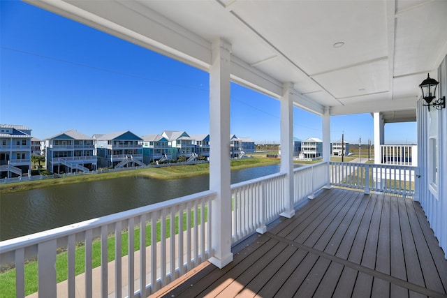 wooden deck with a residential view and a water view