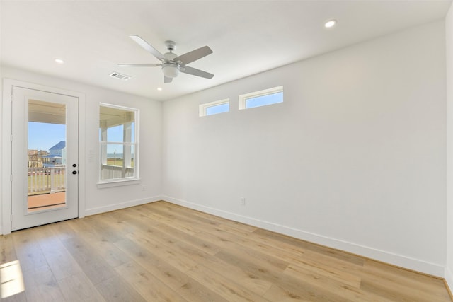 unfurnished room featuring ceiling fan, light wood finished floors, visible vents, and baseboards