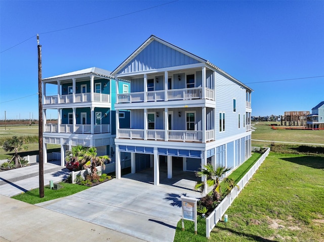 view of front of house featuring driveway, a carport, a front lawn, and board and batten siding