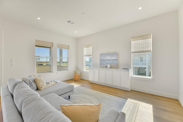 living room featuring visible vents, baseboards, light wood-style flooring, and recessed lighting