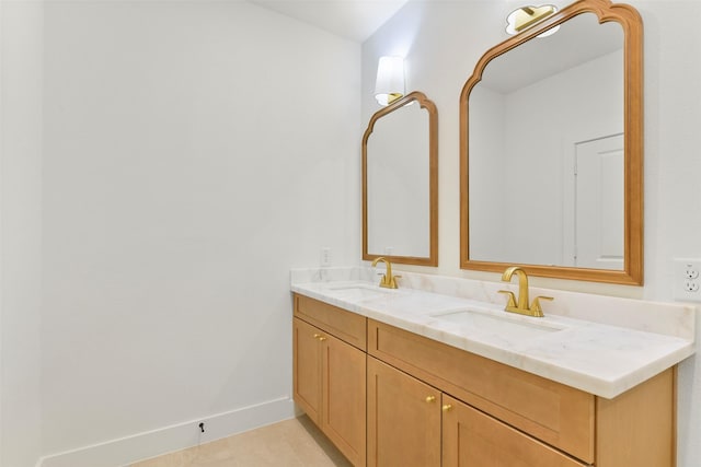 bathroom with tile patterned flooring, a sink, baseboards, and double vanity