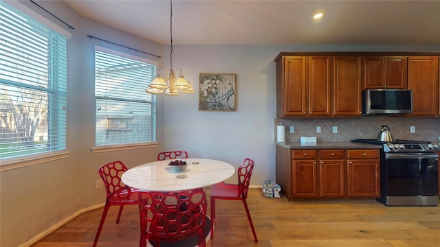 kitchen featuring light wood-style floors, tasteful backsplash, appliances with stainless steel finishes, and brown cabinetry