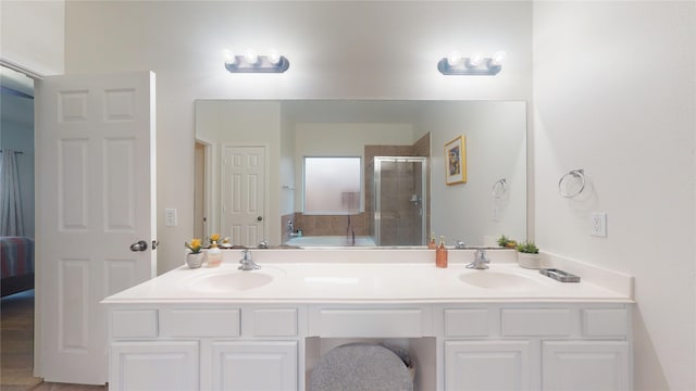 ensuite bathroom featuring a garden tub, connected bathroom, a stall shower, and a sink