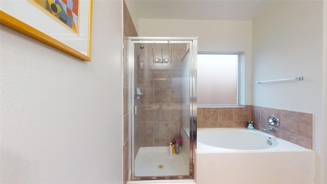 bathroom with a stall shower and a bath