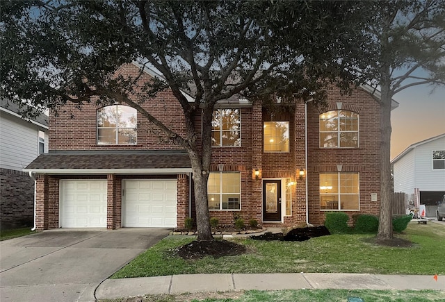 traditional-style house featuring a garage, brick siding, concrete driveway, and a front lawn