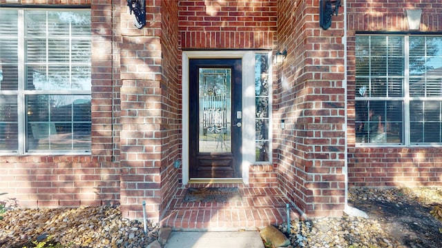 property entrance featuring brick siding