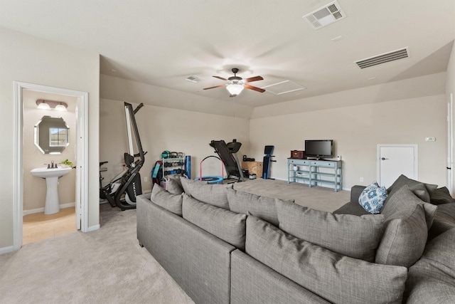 living room featuring attic access, light colored carpet, visible vents, and ceiling fan