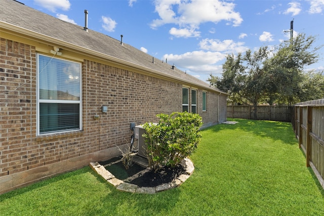 view of yard with a fenced backyard and central AC unit