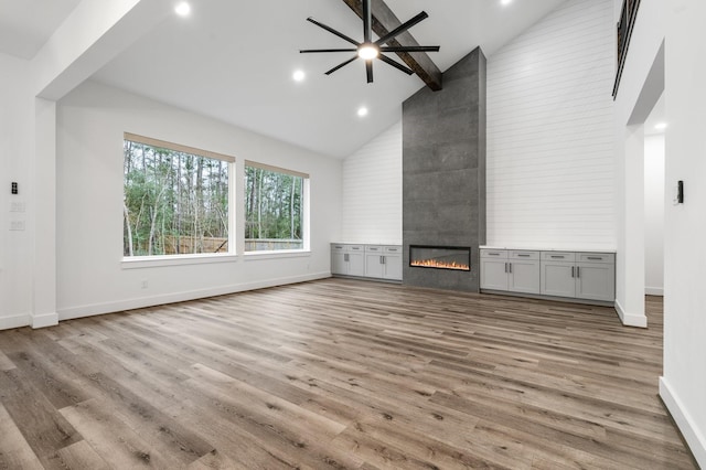 245 E Blue Heron Dr, Montgomery, TX 77316 - unfurnished living room with high vaulted ceiling, a fireplace, wood finished floors, ceiling fan, and recessed lighting
