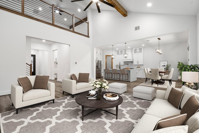 living room with stairs, beam ceiling, high vaulted ceiling, and wood finished floors