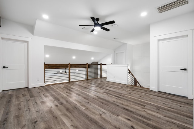 additional living space with a ceiling fan, visible vents, vaulted ceiling, and wood finished floors