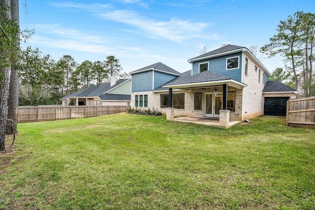 rear view of house with a fenced backyard, brick siding, a ceiling fan, a yard, and a patio area