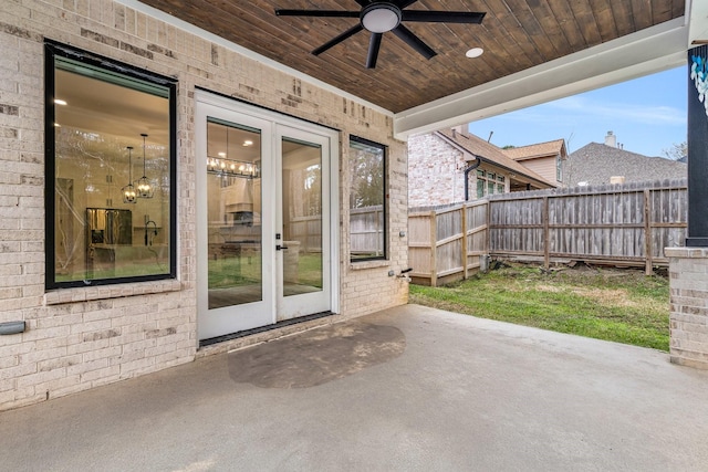 property entrance with a patio, brick siding, fence, a ceiling fan, and french doors