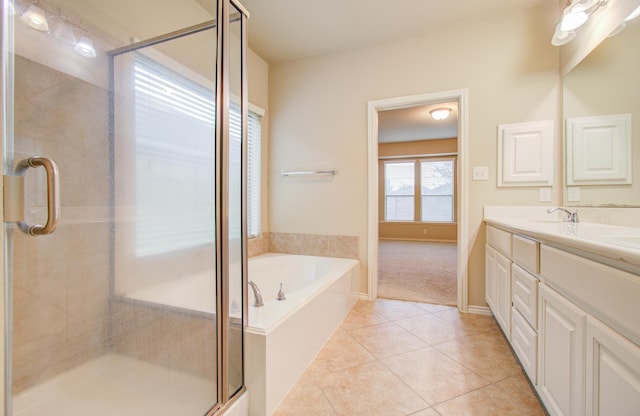 full bath with a garden tub, double vanity, a stall shower, a sink, and tile patterned flooring