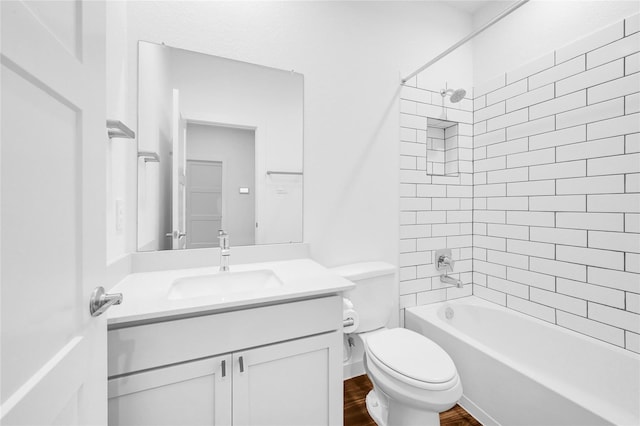 full bath featuring wood finished floors, bathing tub / shower combination, vanity, and toilet