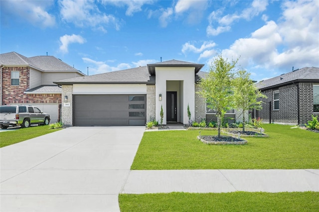 prairie-style house with a front yard, concrete driveway, brick siding, and an attached garage