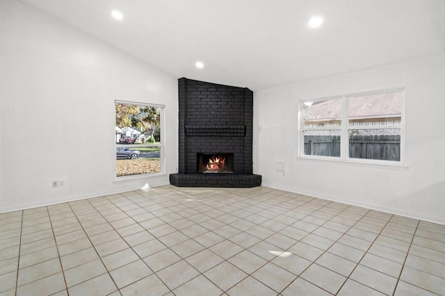 unfurnished living room with vaulted ceiling, a brick fireplace, baseboards, and recessed lighting