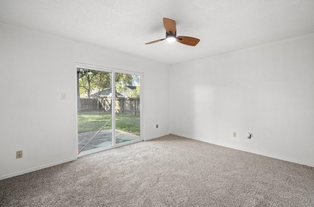 carpeted empty room featuring ceiling fan, a textured ceiling, and baseboards