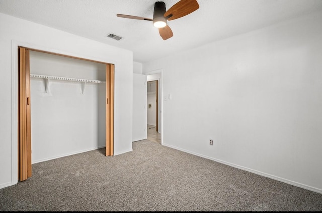 unfurnished bedroom featuring a ceiling fan, visible vents, baseboards, a closet, and carpet