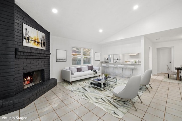 living area featuring lofted ceiling, a brick fireplace, recessed lighting, and light tile patterned floors