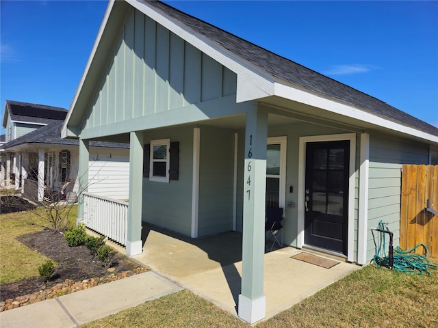 view of exterior entry featuring board and batten siding and a porch