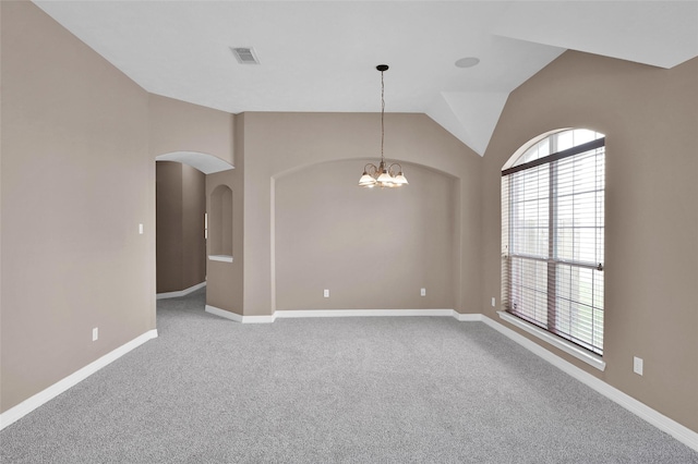 carpeted spare room with a chandelier, visible vents, baseboards, and lofted ceiling