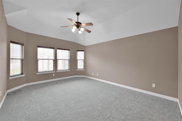 carpeted empty room featuring ceiling fan, baseboards, and lofted ceiling