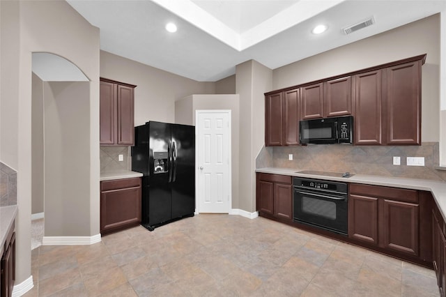 kitchen with visible vents, baseboards, black appliances, light countertops, and tasteful backsplash