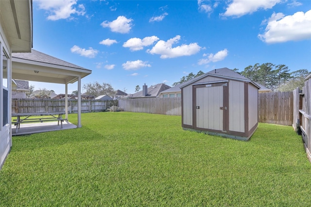 view of yard featuring a storage unit, a patio, an outbuilding, and a fenced backyard