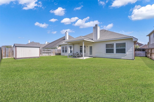 rear view of house featuring a storage shed, an outbuilding, a yard, and a fenced backyard