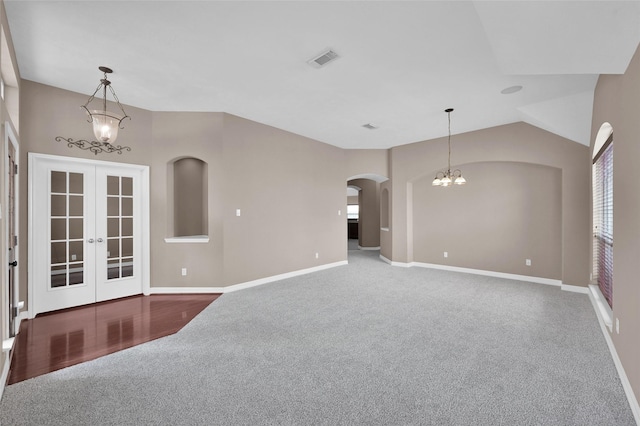 empty room with visible vents, baseboards, lofted ceiling, french doors, and an inviting chandelier