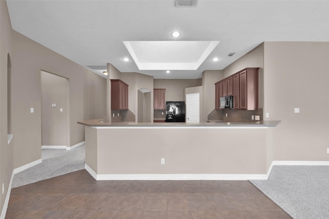 kitchen with arched walkways, black fridge with ice dispenser, carpet flooring, and stainless steel microwave