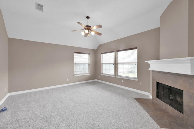 unfurnished living room with visible vents, baseboards, lofted ceiling, a fireplace, and dark colored carpet