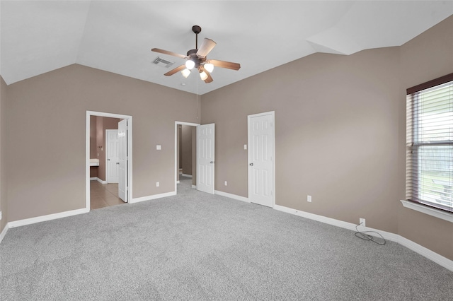 unfurnished bedroom featuring visible vents, light colored carpet, baseboards, and lofted ceiling