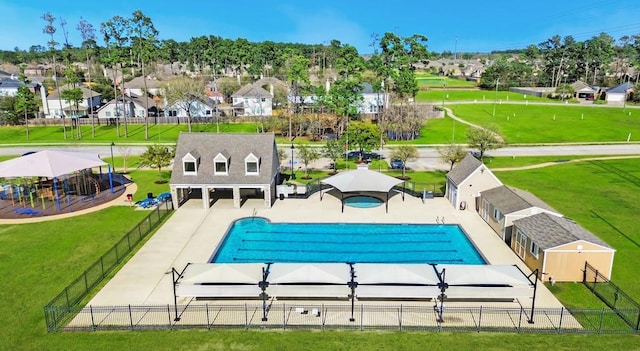 pool featuring a patio area, a residential view, a yard, and fence