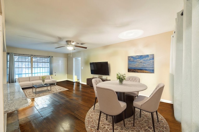 dining room featuring visible vents, hardwood / wood-style floors, a ceiling fan, and baseboards