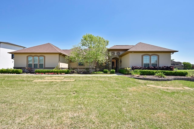 view of front facade with stone siding, a front lawn, and stucco siding