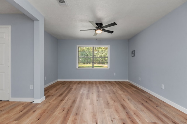 empty room with light wood-style floors, visible vents, ceiling fan, and baseboards