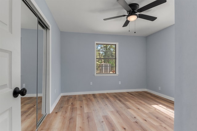 unfurnished bedroom with a ceiling fan, a closet, light wood-style flooring, and baseboards