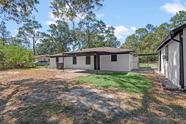 back of house with a patio, a yard, fence, and a gate