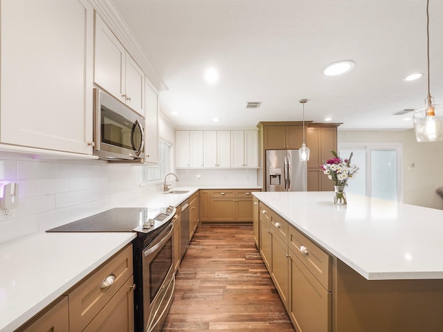 kitchen with light wood-style flooring, appliances with stainless steel finishes, light countertops, and decorative backsplash