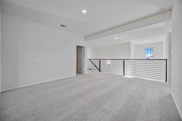 carpeted spare room featuring baseboards, visible vents, and recessed lighting