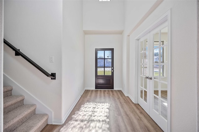 entrance foyer featuring french doors, stairway, wood finished floors, and baseboards