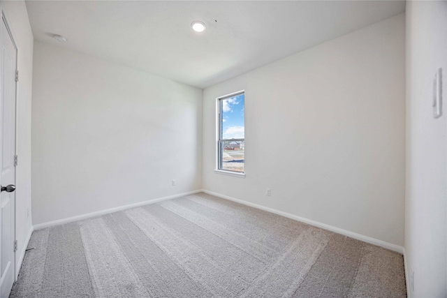 spare room featuring carpet floors and baseboards