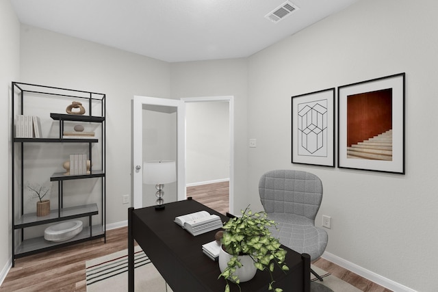 home office featuring visible vents, baseboards, and wood finished floors