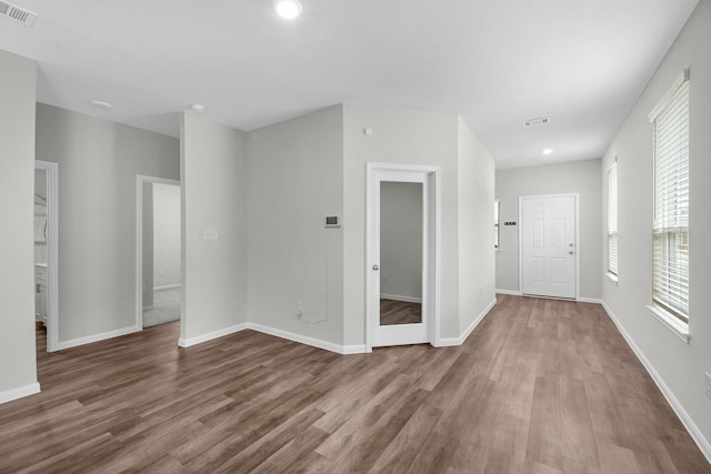 empty room featuring baseboards, visible vents, wood finished floors, and recessed lighting