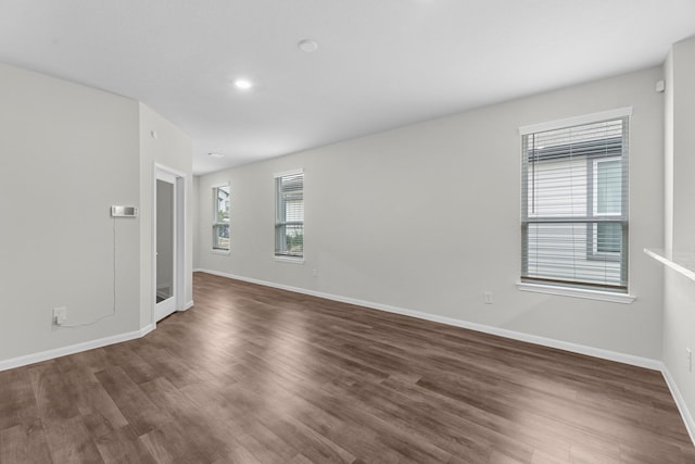 empty room with baseboards and dark wood finished floors