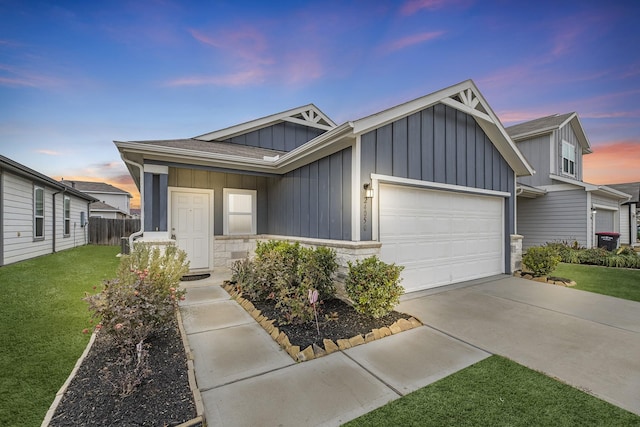 view of front of home featuring a garage, driveway, stone siding, board and batten siding, and a front yard