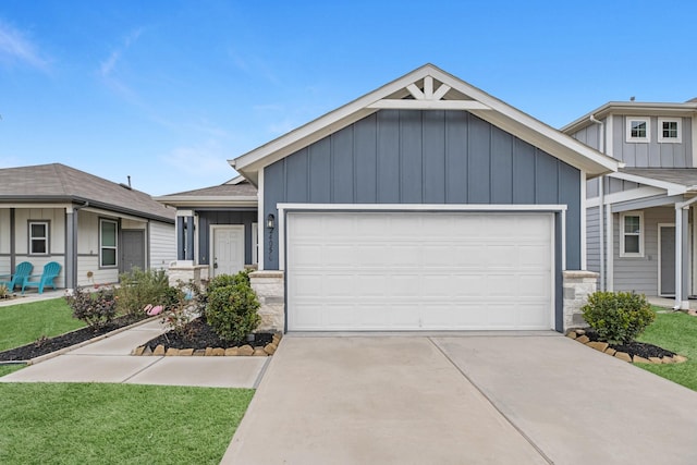 view of front of property with board and batten siding, a front lawn, driveway, and an attached garage