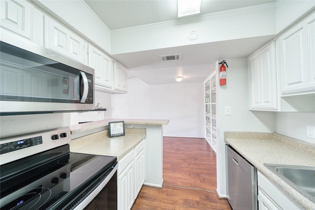 kitchen featuring white cabinetry, visible vents, stainless steel appliances, and light countertops